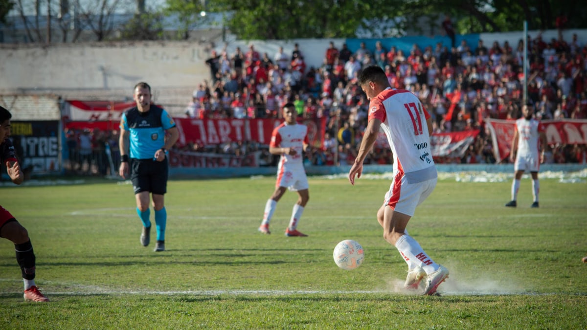 Intense football match showcasing players' skills on a sunny day in Mendoza, Argentina.